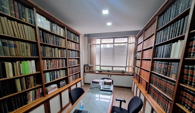 Biblioteca do escritório, com estantes de obras jurídicas
